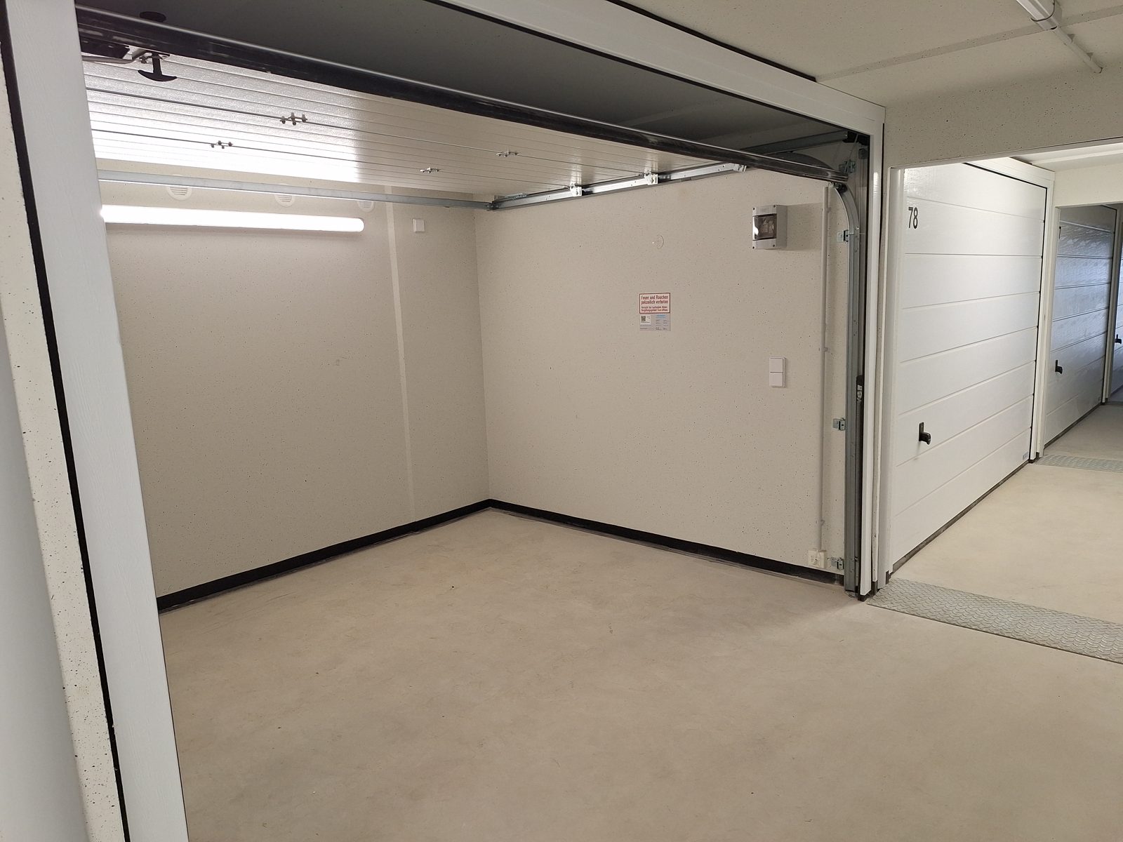 Innenansicht einer Lagerbox bei SPEICHER-BOX Eschweiler mit Sektionaltor und Beleuchtung